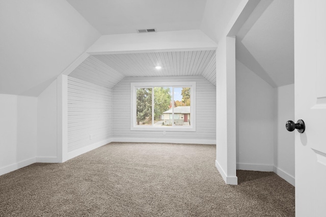 bonus room with vaulted ceiling and carpet