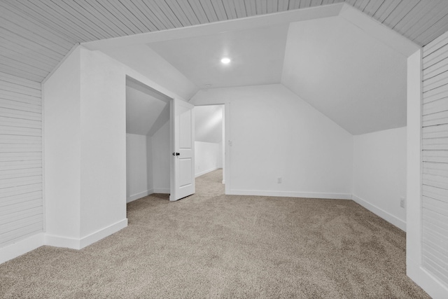 additional living space with vaulted ceiling and light carpet