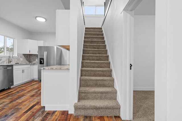 stairs featuring sink and hardwood / wood-style floors