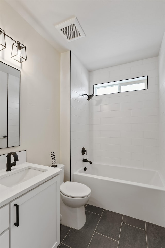 full bathroom with tile patterned flooring, vanity, tiled shower / bath combo, and toilet