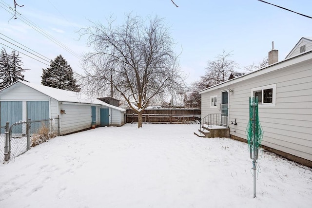 yard layered in snow featuring a shed