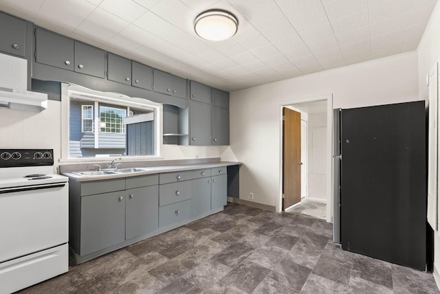 kitchen featuring sink, stainless steel refrigerator, white electric stove, gray cabinets, and backsplash