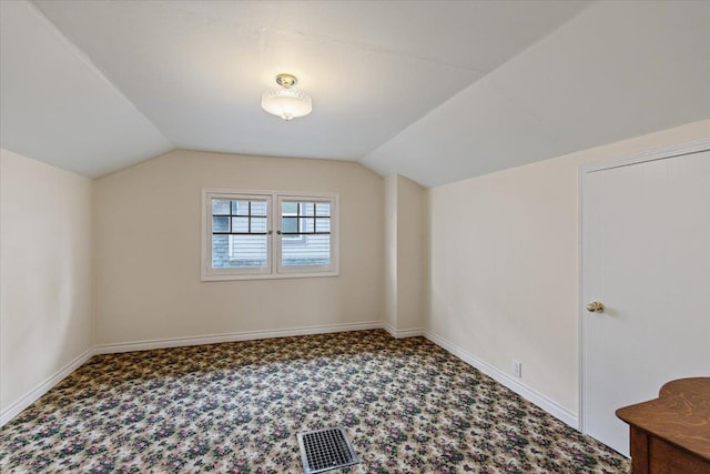 additional living space featuring lofted ceiling and carpet