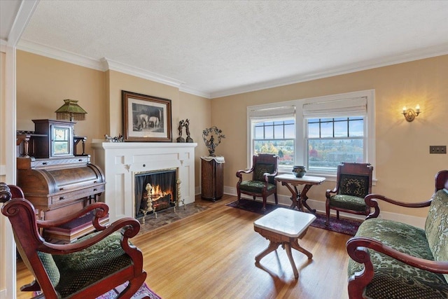 sitting room with crown molding, hardwood / wood-style flooring, and a textured ceiling