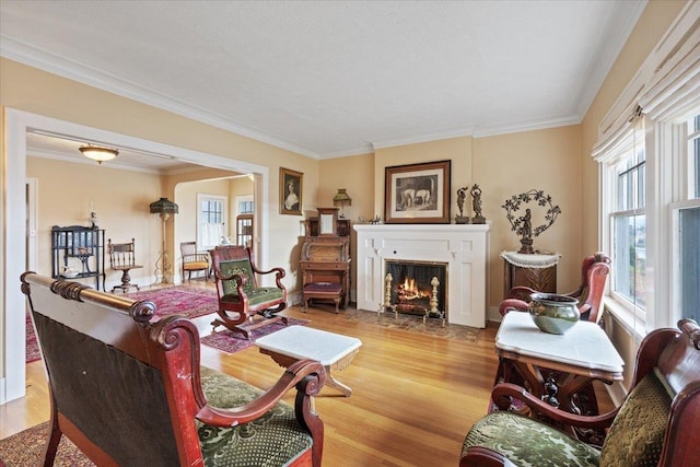 living area with crown molding and light wood-type flooring