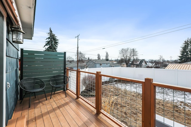 wooden terrace featuring a residential view and a fenced backyard