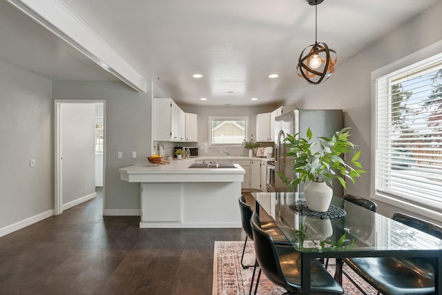 kitchen featuring pendant lighting, appliances with stainless steel finishes, backsplash, white cabinets, and dark hardwood / wood-style flooring