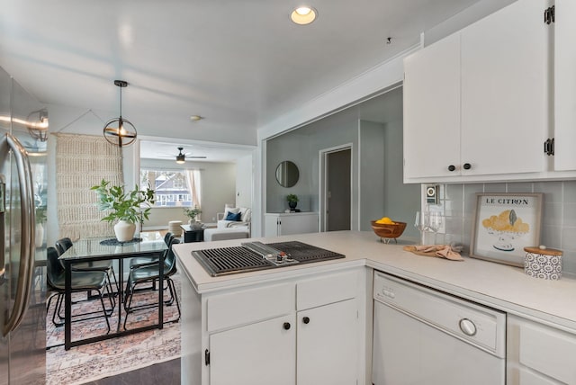 kitchen featuring appliances with stainless steel finishes, tasteful backsplash, white cabinets, hanging light fixtures, and kitchen peninsula