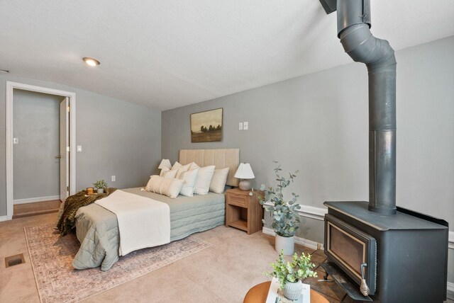 carpeted bedroom with a wood stove