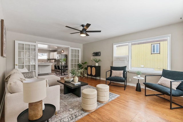 living room featuring ceiling fan, a wealth of natural light, and light hardwood / wood-style floors