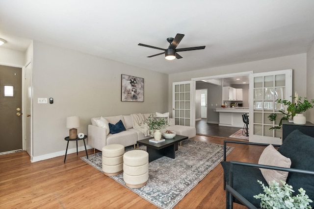 living room with wood-type flooring, ceiling fan, and french doors