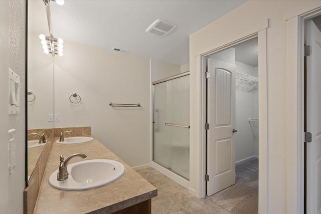 bathroom with walk in shower, vanity, a chandelier, and a textured ceiling