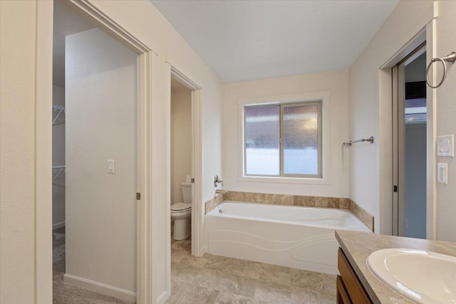 bathroom with vanity, a bathtub, and toilet