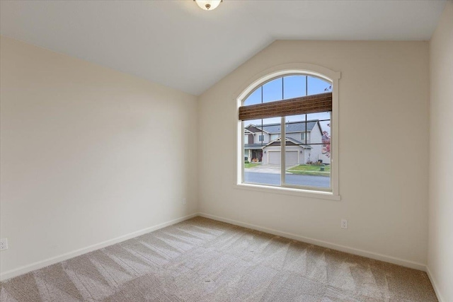 carpeted spare room featuring lofted ceiling