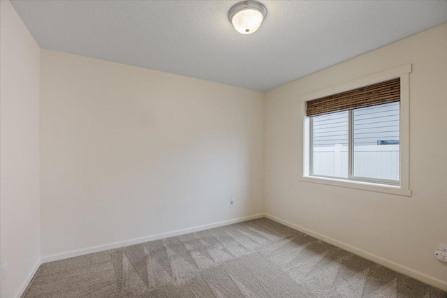 unfurnished room with a textured ceiling and carpet flooring