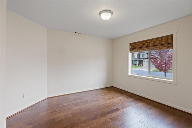 unfurnished room with hardwood / wood-style flooring