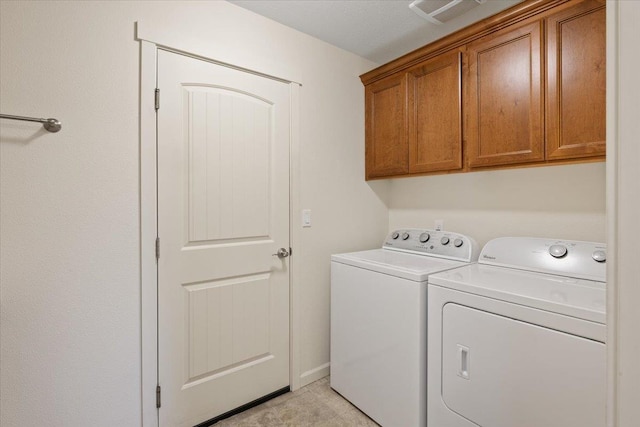 washroom with washing machine and dryer and cabinets