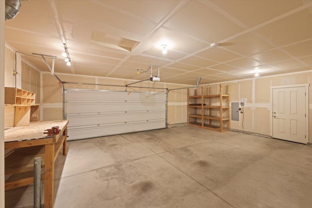 garage with a garage door opener and electric panel