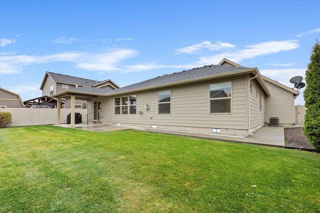 back of property with central AC unit, a lawn, and a patio