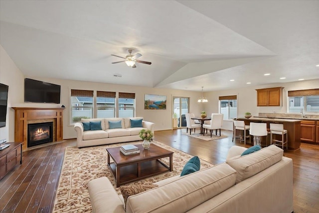 living room featuring ceiling fan, lofted ceiling, dark hardwood / wood-style flooring, and sink