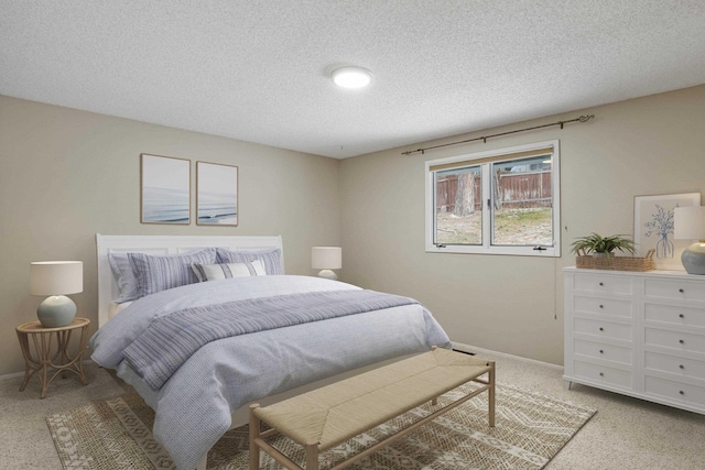 bedroom featuring light carpet and a textured ceiling