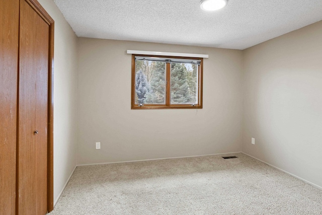 unfurnished bedroom featuring carpet, a closet, and a textured ceiling