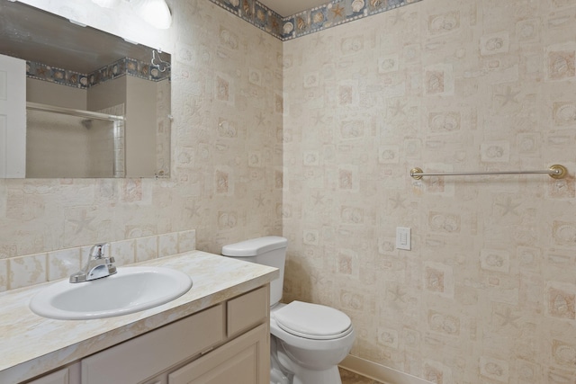 bathroom with vanity, toilet, and a shower with shower door