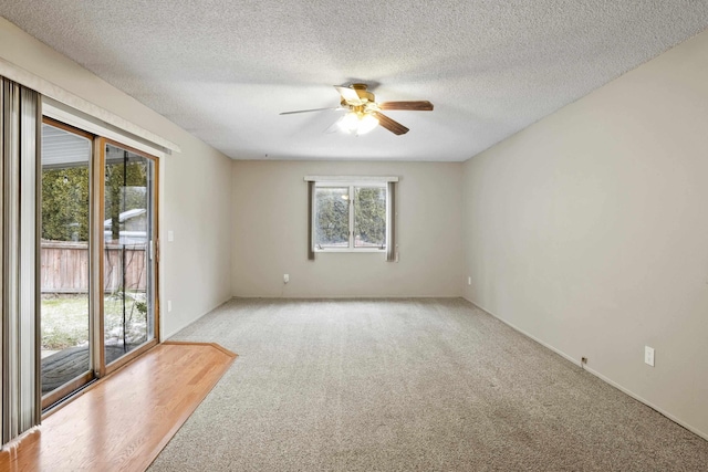 carpeted empty room featuring ceiling fan and a textured ceiling