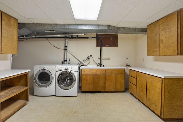 washroom with washing machine and dryer and cabinets