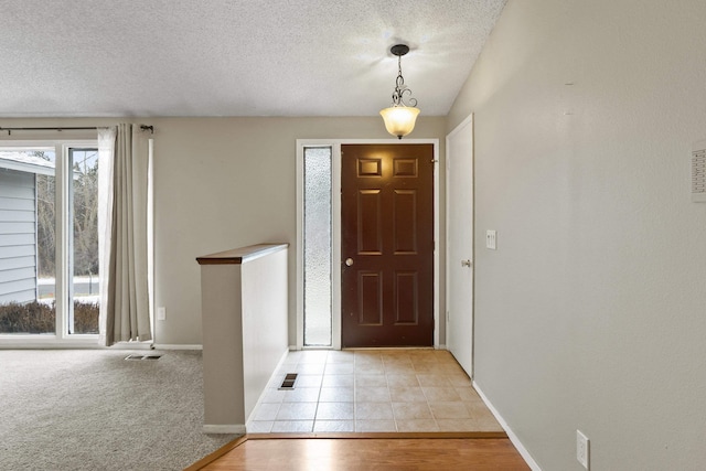 tiled foyer with a textured ceiling