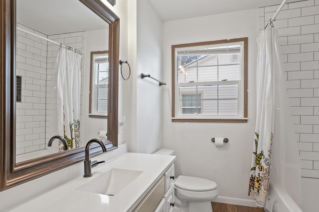 full bathroom featuring vanity, shower / bath combo with shower curtain, and toilet