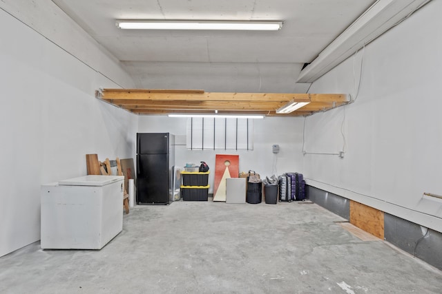 basement featuring black refrigerator and fridge