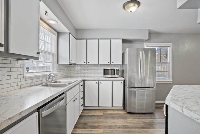 kitchen featuring sink, white cabinetry, tasteful backsplash, appliances with stainless steel finishes, and dark hardwood / wood-style floors