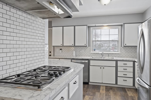 kitchen with white cabinetry, appliances with stainless steel finishes, sink, and light stone counters