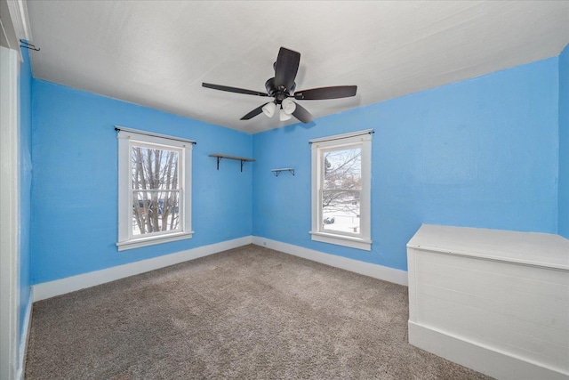 carpeted empty room with ceiling fan and a healthy amount of sunlight