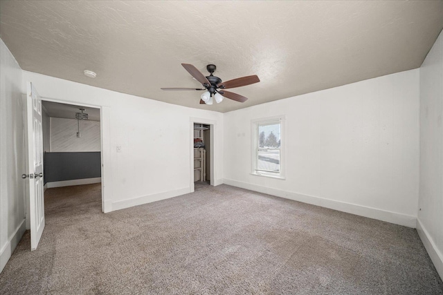 unfurnished bedroom featuring ceiling fan, carpet floors, a closet, and a textured ceiling