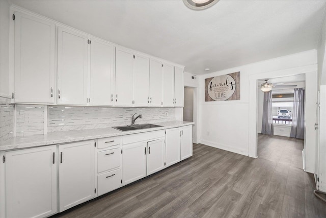 kitchen featuring tasteful backsplash, wood-type flooring, sink, and white cabinets