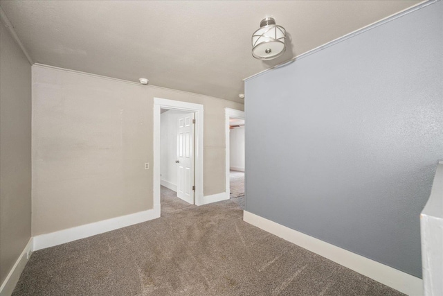 carpeted spare room featuring crown molding