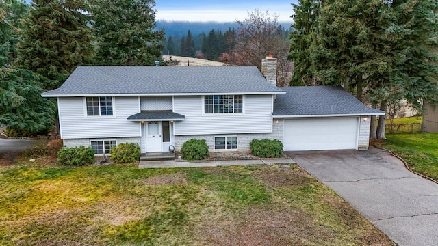 split foyer home with a garage and a front yard