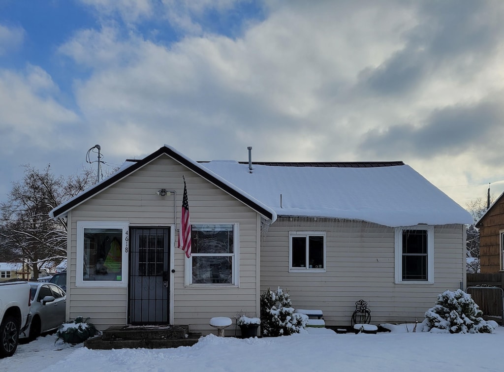 view of snow covered back of property