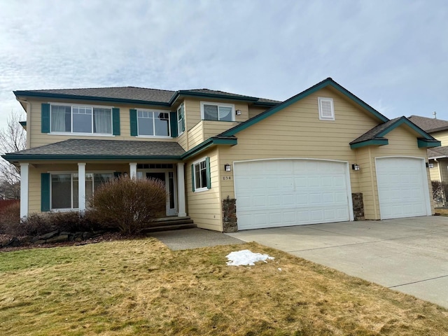 view of front of property with driveway, an attached garage, and a front yard