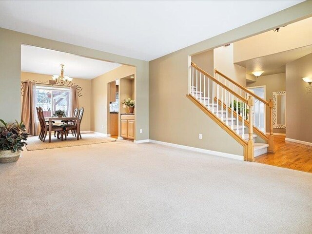 854 S Shelley Lake Ln, Spokane Valley, WA 99037 - interior space featuring light carpet, stairs, baseboards, and a notable chandelier