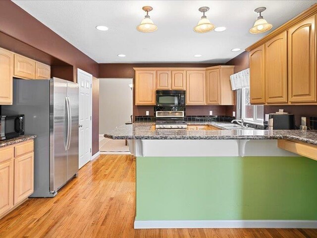854 S Shelley Lake Ln, Spokane Valley, WA 99037 - kitchen with light wood-style floors, dark stone counters, black microwave, and range