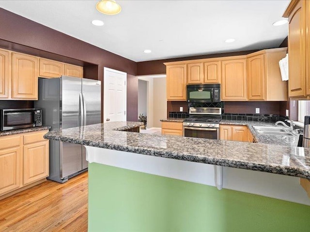 854 S Shelley Lake Ln, Spokane Valley, WA 99037 - kitchen with dark stone counters, light brown cabinetry, appliances with stainless steel finishes, and a sink