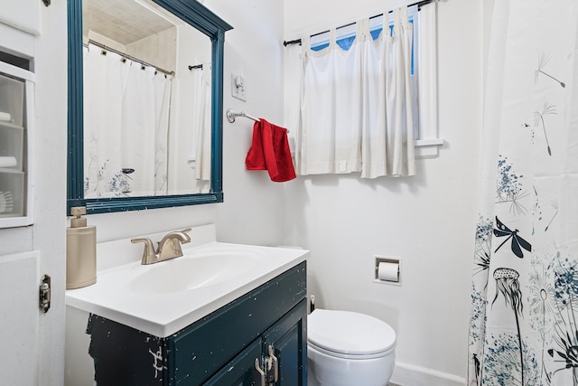 bathroom with vanity, curtained shower, and toilet