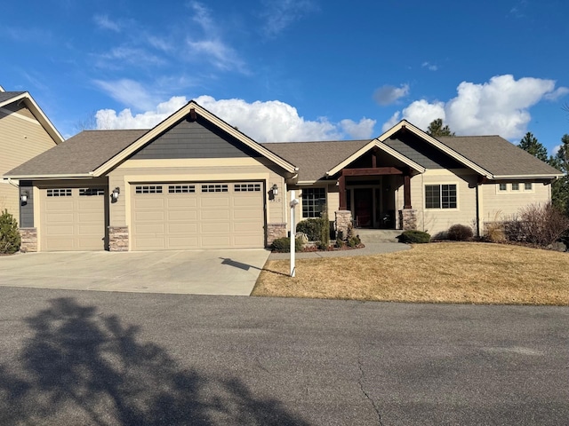 craftsman-style home featuring a garage, stone siding, and concrete driveway