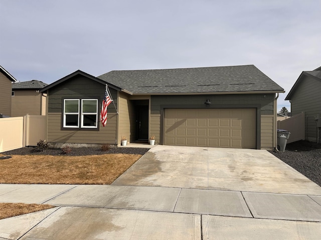 ranch-style house with a garage, driveway, a shingled roof, and fence