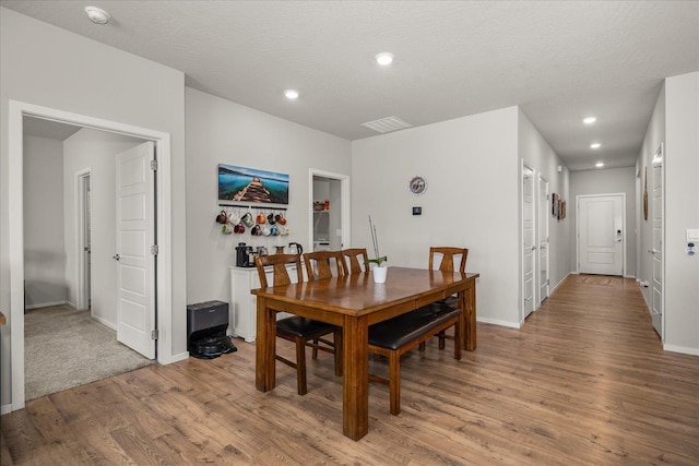 dining room featuring a textured ceiling, recessed lighting, baseboards, and light wood-style floors