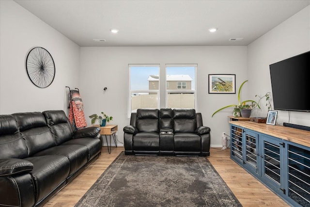 living area with light wood-type flooring, visible vents, and recessed lighting