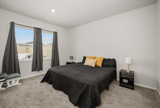 carpeted bedroom with visible vents and baseboards